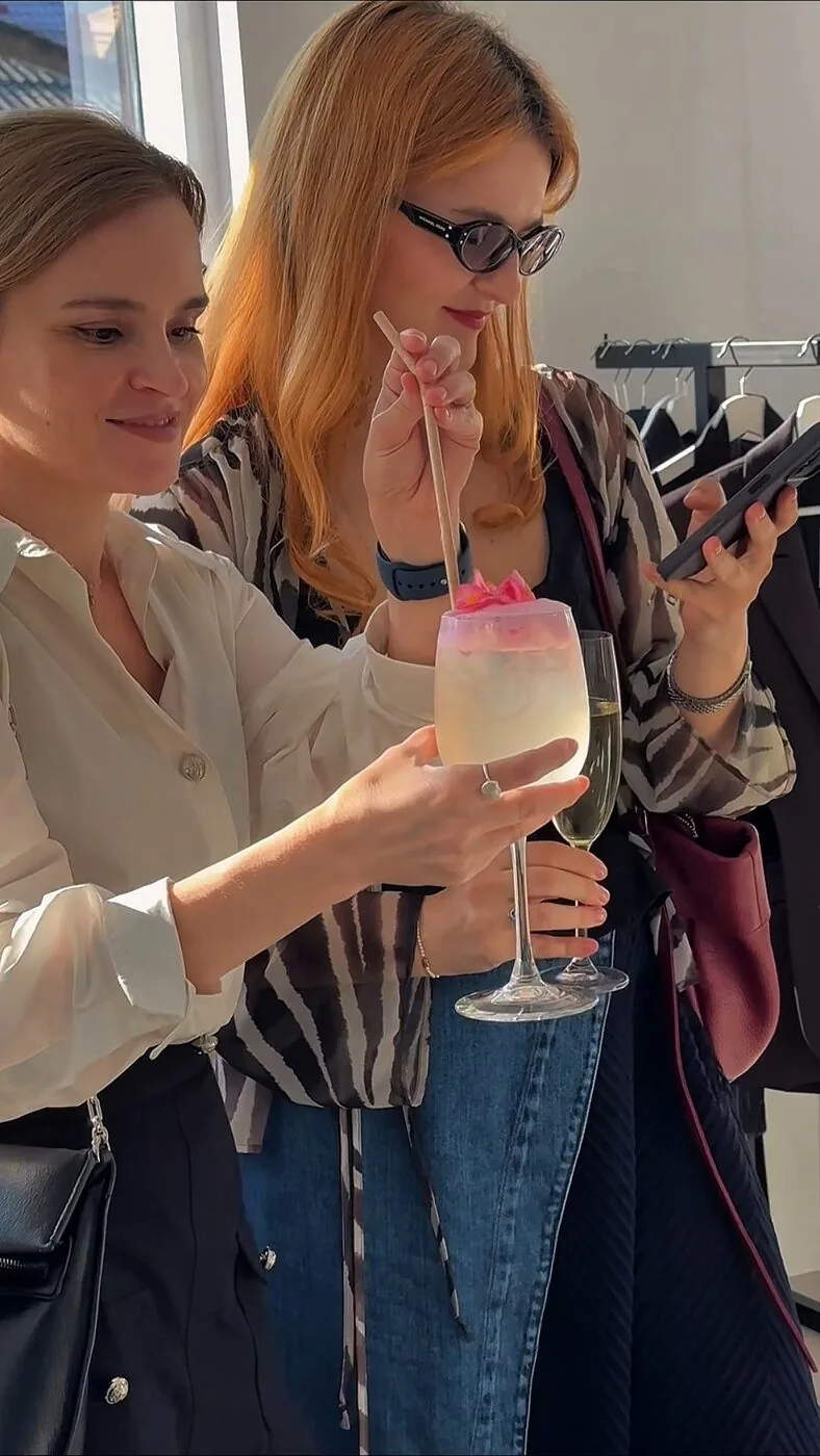 A guest admiring a cocktail garnished with a flower